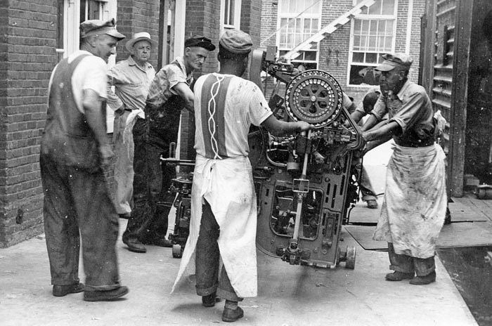 milll workers moving equipment