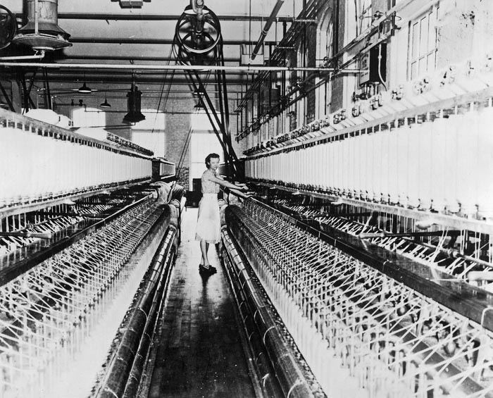 Lady with spools in old mill spinning room